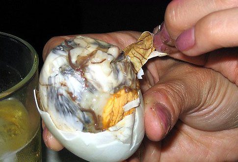 Opened balut duck egg showing the boiled embryo inside